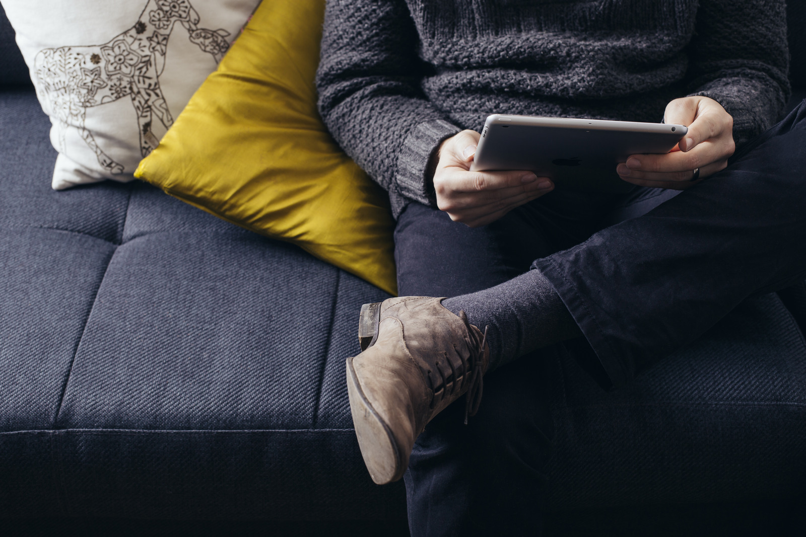man using ipad on couch