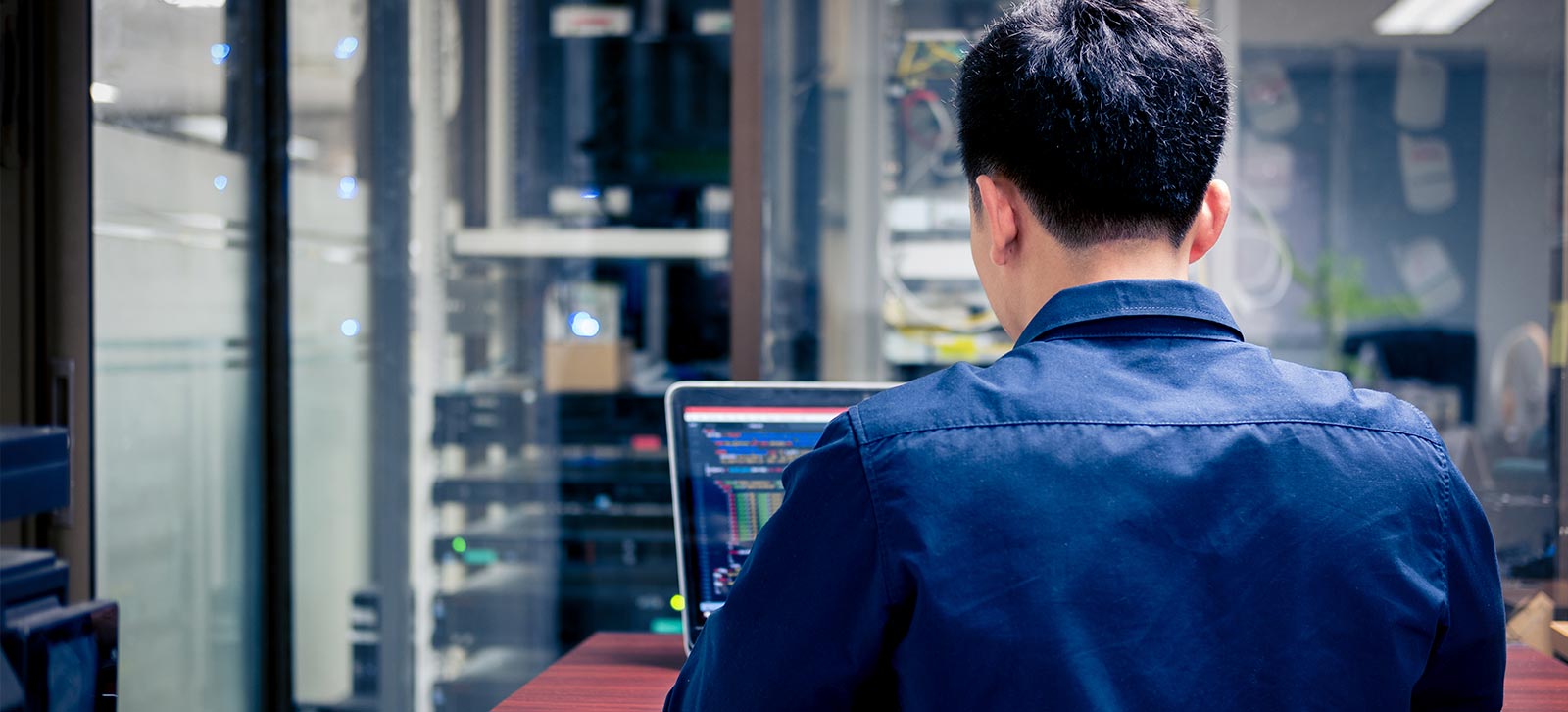 Male typing on a computer in the server room