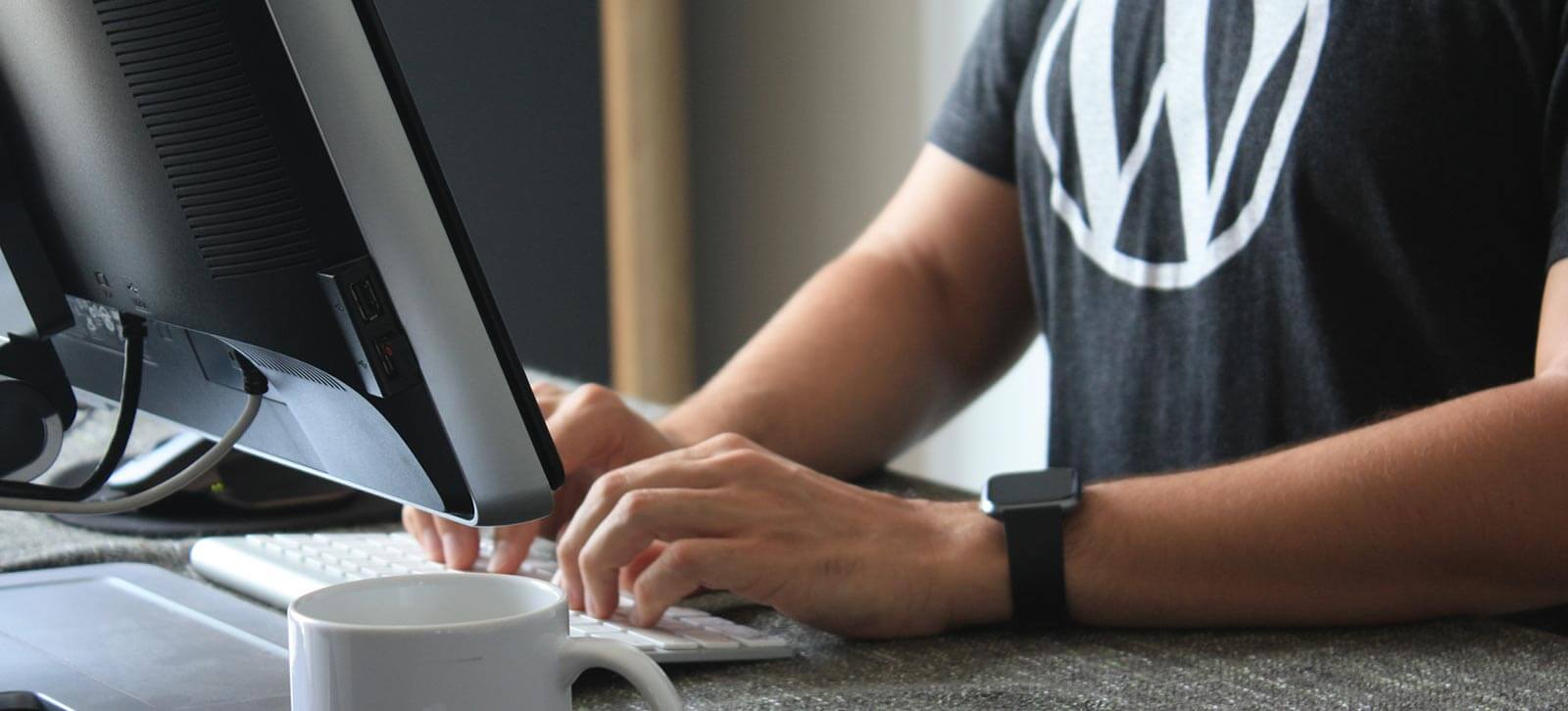 Close up of a WordPress developer typing on a computer keyboard.