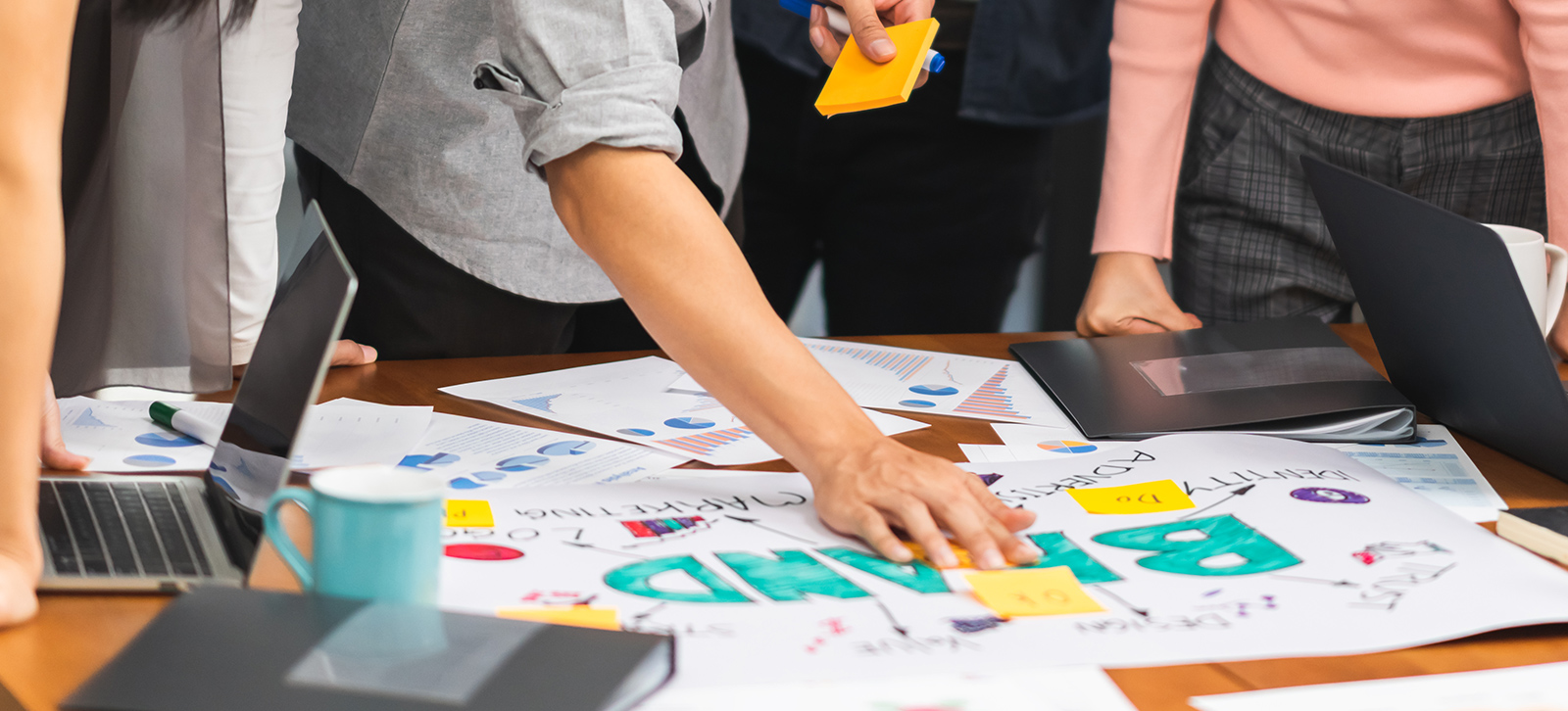 Designers brainstorming brand concepts over a table full sketches