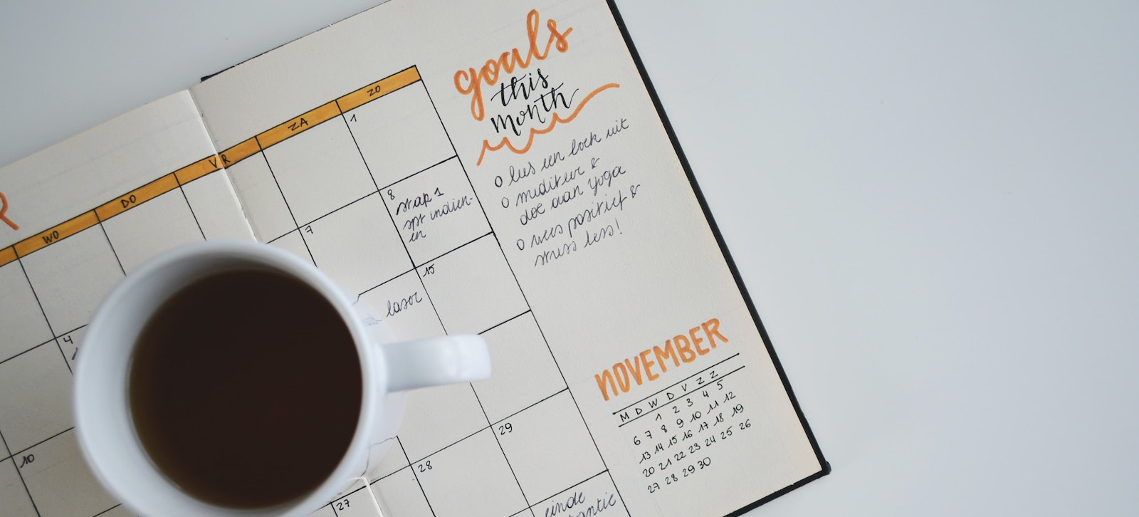 coffee mug next to a planner