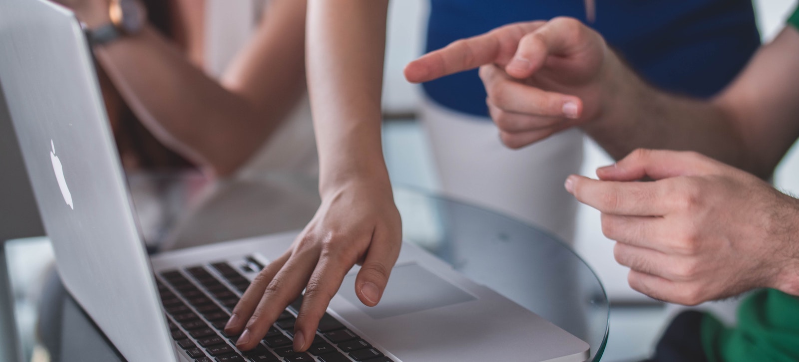 hands hovering over a laptop computer