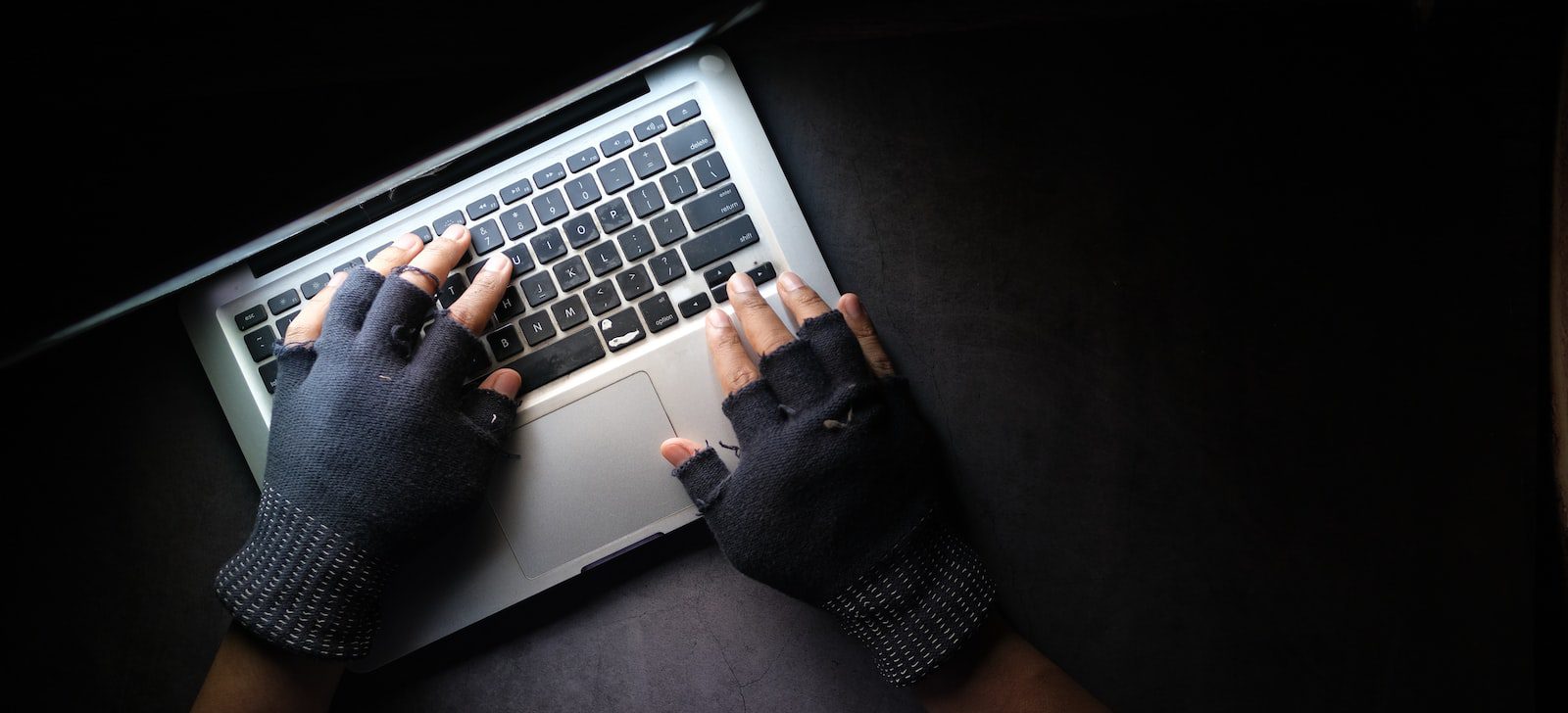 person in black long sleeve shirt using macbook pro