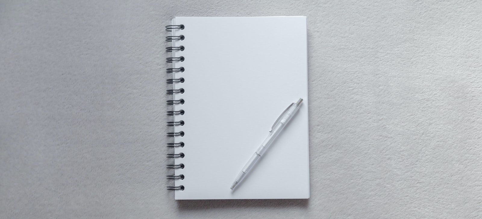 white notebook with pen on top