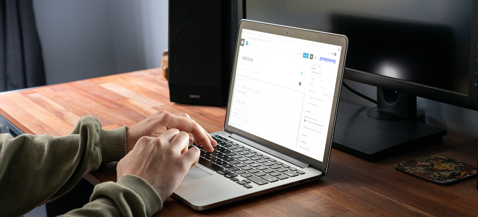 person in gray jacket using macbook pro