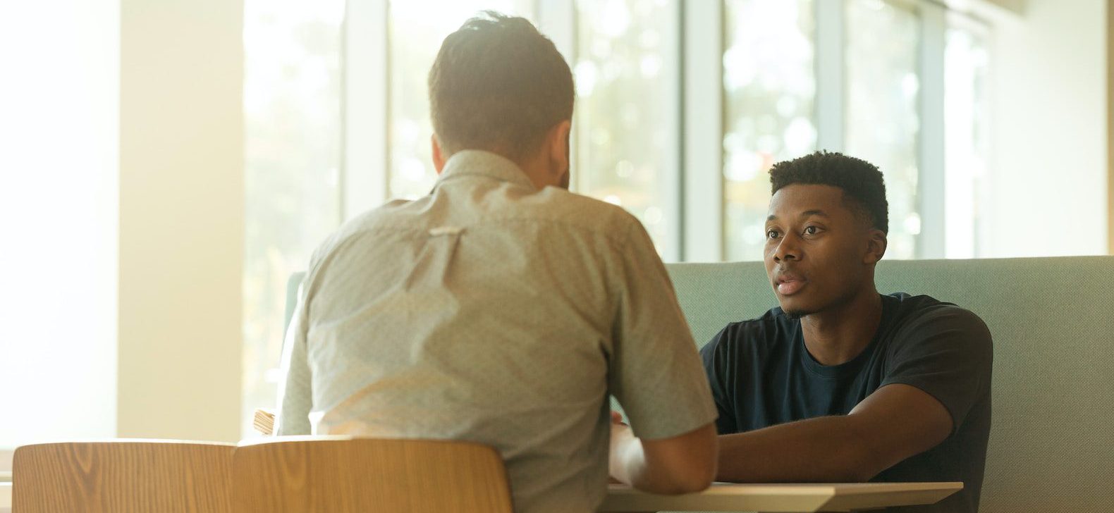 Two men having a serious conversation in a booth