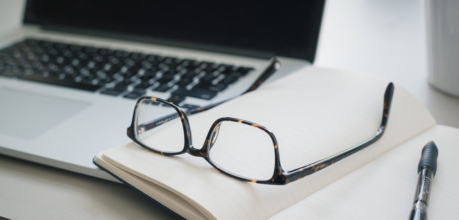 black framed eyeglasses and black pen