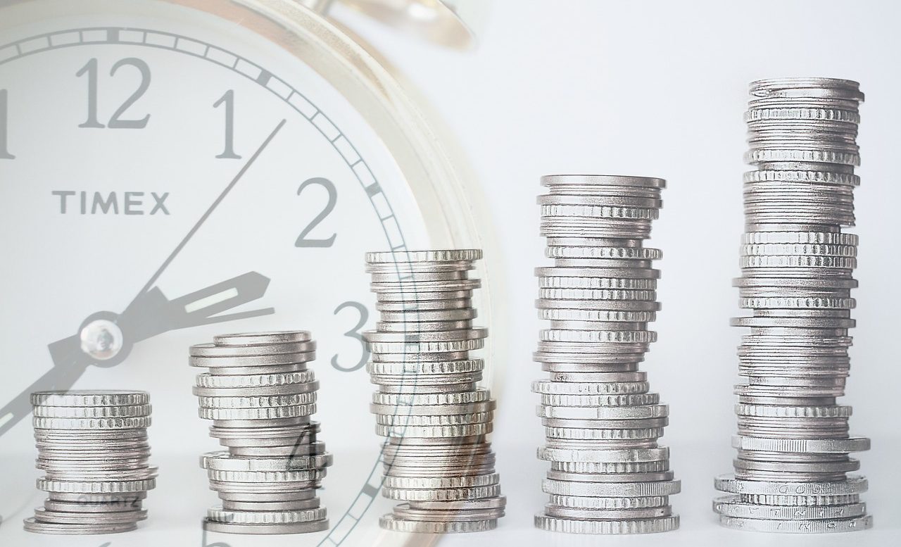 A photo collage of gradually increasing stacks of coins in front of an image of a clock